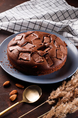 Chocolate cake with chocolate pieces on a brown background