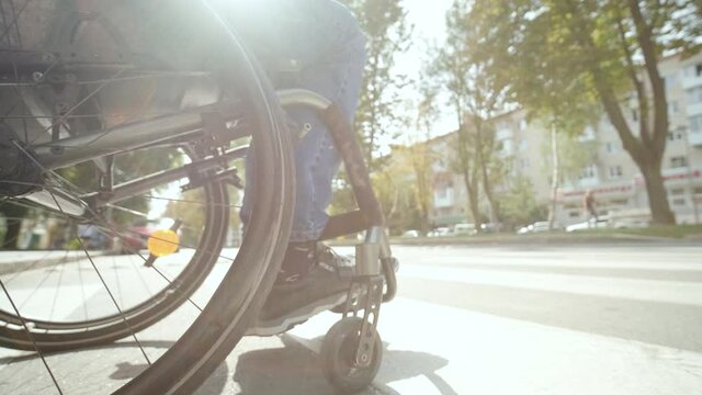 Handicapped man in wheelchair crossing street road