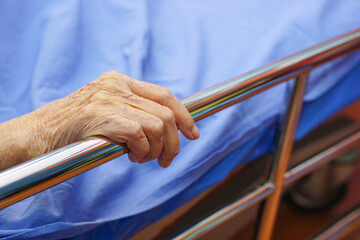Close up The hands of an Asian senior or elderly old woman patient as grab at the edge of the bed...
