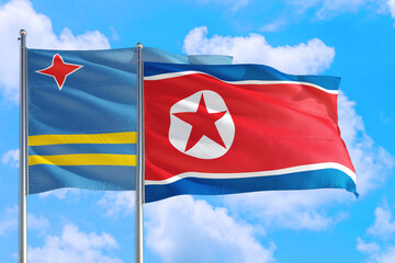 North Korea and Aruba national flag waving in the windy deep blue sky. Diplomacy and international relations concept.