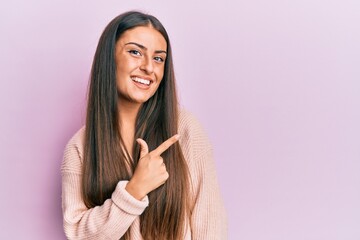 Beautiful hispanic woman wearing casual clothes smiling cheerful pointing with hand and finger up to the side