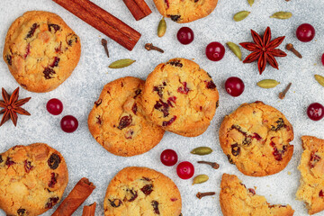 Freshly baked homemade cookies with cranberries, almonds, white chocolate and spices (cinnamon, cardamom, cloves, star anise) close-up. Oatmeal biscuits. Christmas, New year. Selective focus