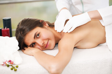 Obraz na płótnie Canvas Beautiful woman getting massage in spa, brunette lying resting.