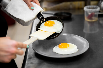 Fried eggs with two yolks are laid out from a frying pan on a plate