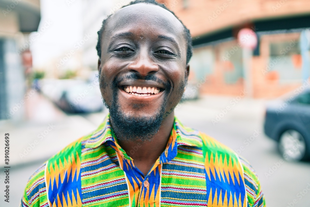 Poster Young african american man smiling happy standing at street of city.