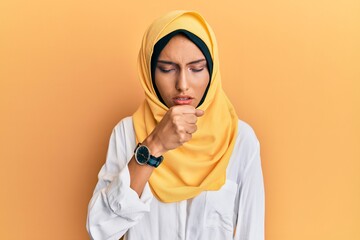 Young brunette arab woman wearing traditional islamic hijab scarf feeling unwell and coughing as symptom for cold or bronchitis. health care concept.