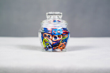 wide view of a jar of multi colored can pull tabs