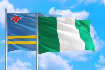 Nigeria and Aruba national flag waving in the windy deep blue sky. Diplomacy and international relations concept.