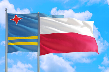 Poland and Aruba national flag waving in the windy deep blue sky. Diplomacy and international relations concept.