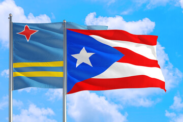 Puerto Rico and Aruba national flag waving in the windy deep blue sky. Diplomacy and international relations concept.