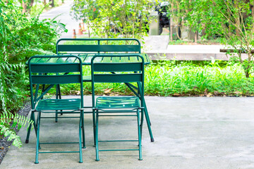 Green metal chairs and table set in the garden