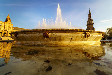 Fuente de la Plaza de España en Sevilla al atardecer en un día soleado y cielo azul.