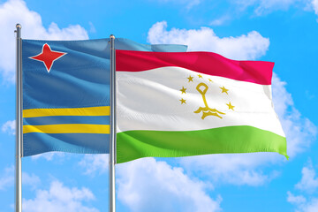 Tajikistan and Aruba national flag waving in the windy deep blue sky. Diplomacy and international relations concept.