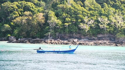 Naklejka na ściany i meble Long Tail boat crossing the ocean in a beautiful island