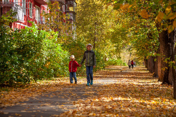 Fototapeta na wymiar Two brothers are walking around a picturesque autumn town. Novosibirsk, Akademgorodok.