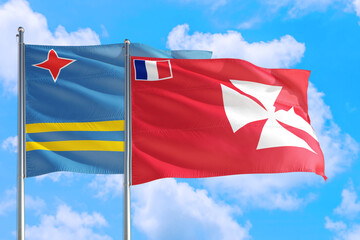 Wallis And Futuna and Aruba national flag waving in the windy deep blue sky. Diplomacy and international relations concept.