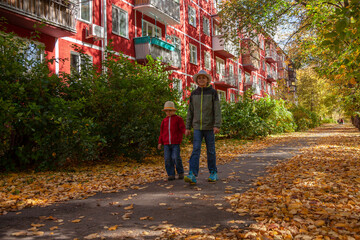 Fototapeta na wymiar Two brothers are walking around a picturesque autumn town. Novosibirsk, Akademgorodok.