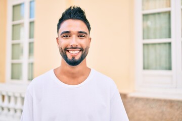 Young arab man smiling happy walking at the city.