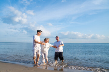 Family On Summer Beach Vacation, Father and mather running with son, Concept for .caring for the elderly, Caregiving to older persons and relations of the family to support elderly state
