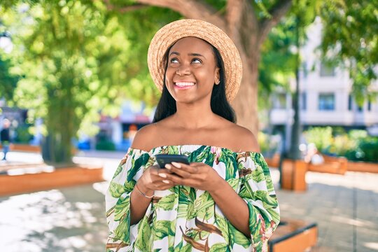 Young african american tourist woman on vacation smiling happy using smartphone at the city.