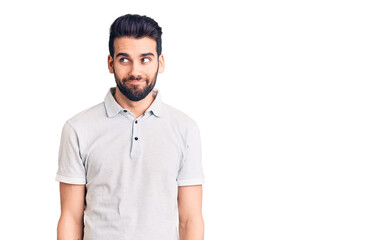 Fototapeta premium Young handsome man with beard wearing casual polo smiling looking to the side and staring away thinking.