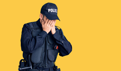 Young handsome man with beard wearing police uniform with sad expression covering face with hands while crying. depression concept.