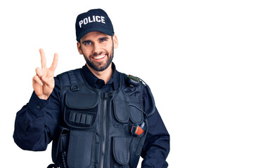 Young handsome man with beard wearing police uniform showing and pointing up with fingers number two while smiling confident and happy.