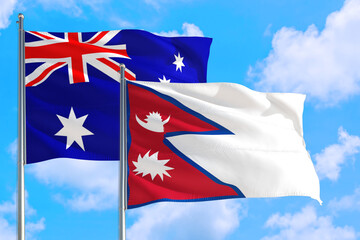 Nepal and Australia national flag waving in the windy deep blue sky. Diplomacy and international relations concept.