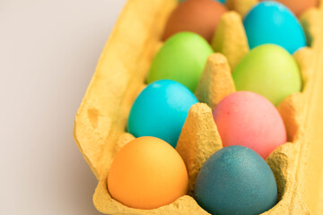 Fototapeta na wymiar Colored painted Easter eggs in craft factory packaging yellow.