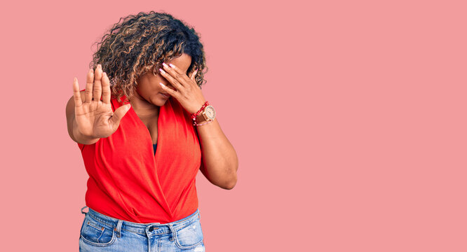 Young african american plus size woman wearing casual style with sleeveless shirt covering eyes with hands and doing stop gesture with sad and fear expression. embarrassed and negative concept.