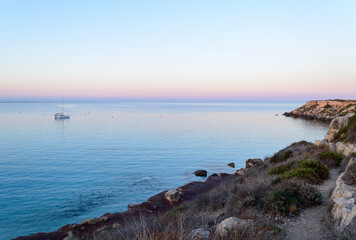 Cristal clear water and no people at the famous Cala Azzurra in Favignana, Italy. A perfect calm sunrise in this paradise island in the mediterranean sea