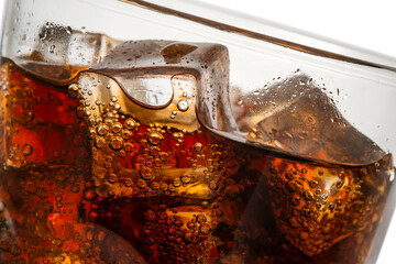 Cola with ice cubes close up