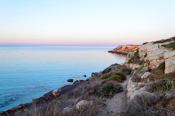 Cristal clear water and no people at the famous Cala Azzurra in Favignana, Italy. A perfect calm sunrise in this paradise island in the mediterranean sea