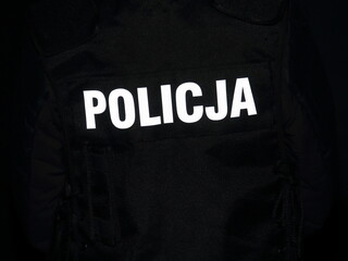 Fototapeta na wymiar Isolated white word POLICE in Polish language on black background