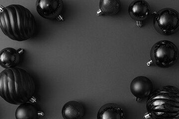 Black balls on black background. Christmas, new year composition. Black friday sale concept. Minimal style. Flat lay, top view, copy space.