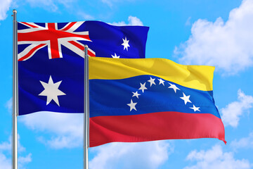 Venezuela and Australia national flag waving in the windy deep blue sky. Diplomacy and international relations concept.