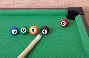 Billiard balls on green table with new year numbers