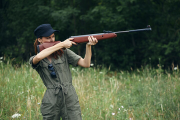 Woman With weapons in hand, nature takes aim green overalls 