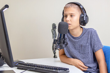 Teenager wearing headphones talk using microphone. Boy recording podcast, online learning from home