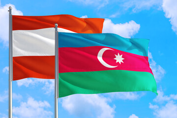 Azerbaijan and Austria national flag waving in the windy deep blue sky. Diplomacy and international relations concept.
