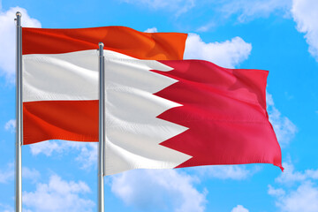 Bahrain and Austria national flag waving in the windy deep blue sky. Diplomacy and international relations concept.