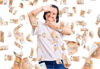 Brunette woman with down syndrome wearing casual white tshirt smiling cheerful playing peek a boo...