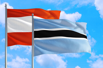 Botswana and Austria national flag waving in the windy deep blue sky. Diplomacy and international relations concept.