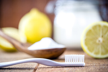 toothbrush with glass with baking soda and citrus fruits like lemon or orange in the background. Spot focus