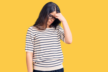 Brunette teenager girl wearing casual clothes and glasses tired rubbing nose and eyes feeling fatigue and headache. stress and frustration concept.