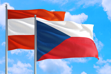 Obraz na płótnie Canvas Czech Republic and Austria national flag waving in the windy deep blue sky. Diplomacy and international relations concept.