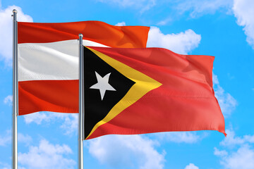 East Timor and Austria national flag waving in the windy deep blue sky. Diplomacy and international relations concept.