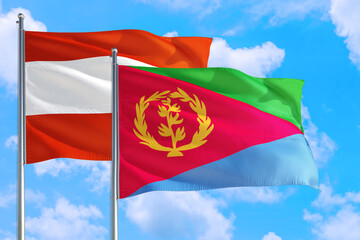 Eritrea and Austria national flag waving in the windy deep blue sky. Diplomacy and international relations concept.