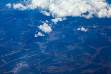 Flying above blue land and white clouds 