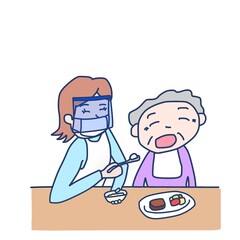 高齢者に食事の介助をしている女性（マスク、フェイスシールドあり）